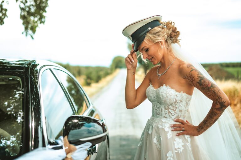 nevěsta v policejní čepici stojí vedle auta