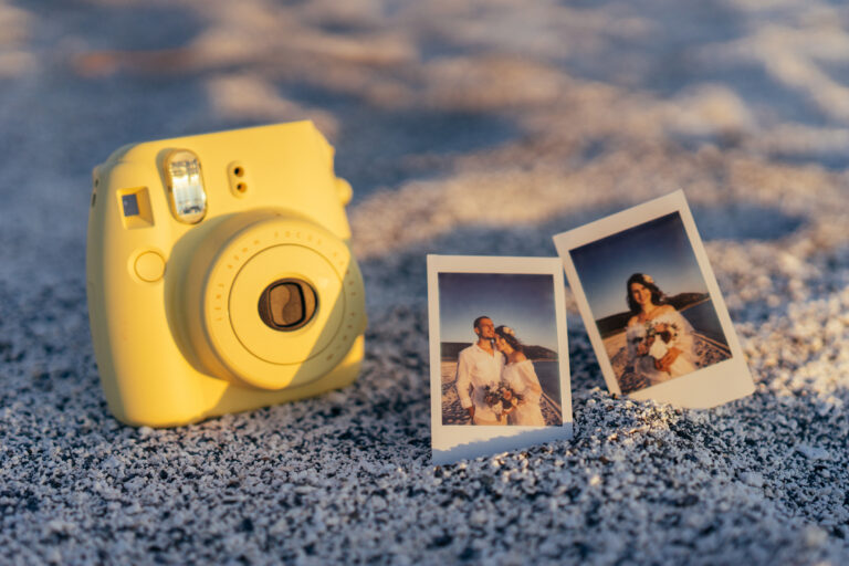 žlutý polaroid se svatebními fotkami na písku